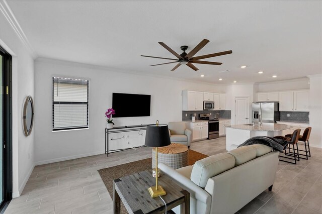 living room featuring ornamental molding and ceiling fan