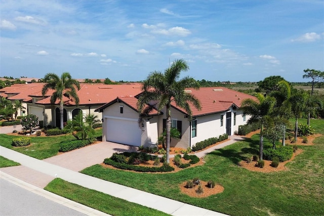 mediterranean / spanish-style home with a front yard and a garage