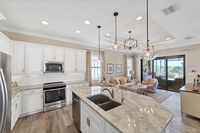 kitchen with light hardwood / wood-style floors, white cabinetry, a healthy amount of sunlight, and appliances with stainless steel finishes