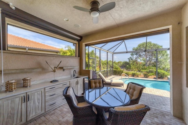 sunroom / solarium featuring ceiling fan and sink