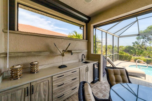 view of patio / terrace with area for grilling, sink, glass enclosure, and wine cooler