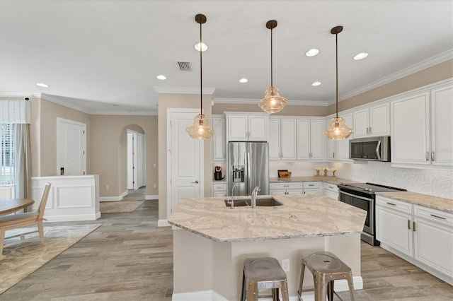 kitchen featuring white cabinetry, a kitchen island with sink, and appliances with stainless steel finishes