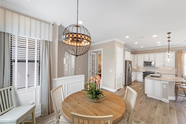 dining space featuring light hardwood / wood-style floors and ornamental molding