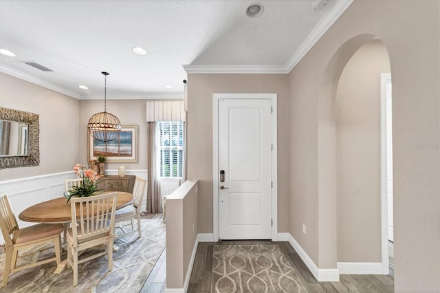 entryway with hardwood / wood-style floors and crown molding