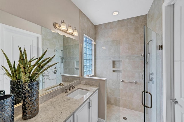 bathroom with vanity and a shower with door