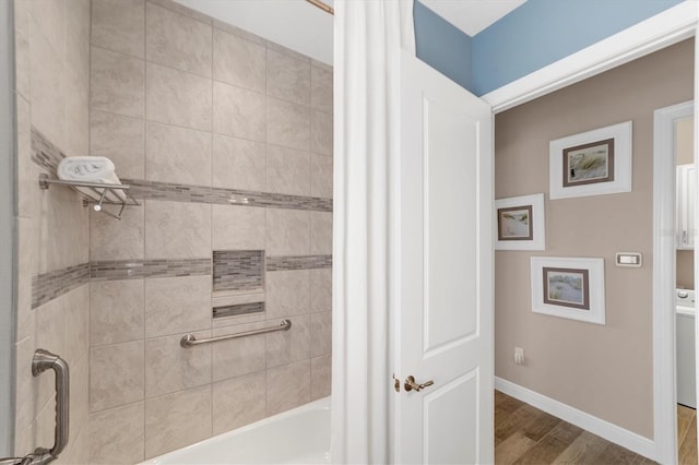 bathroom with hardwood / wood-style floors, shower / tub combo, and washer / dryer