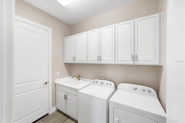 washroom with cabinets, independent washer and dryer, light hardwood / wood-style flooring, and sink