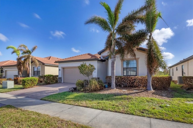 mediterranean / spanish house featuring cooling unit, a front lawn, and a garage