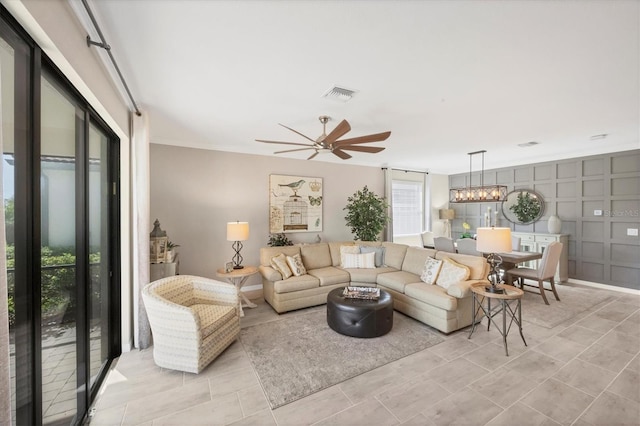 living room featuring ceiling fan with notable chandelier