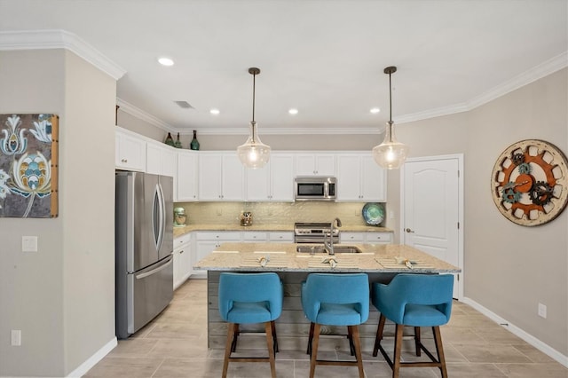 kitchen featuring stainless steel appliances, a center island with sink, crown molding, light stone countertops, and white cabinets