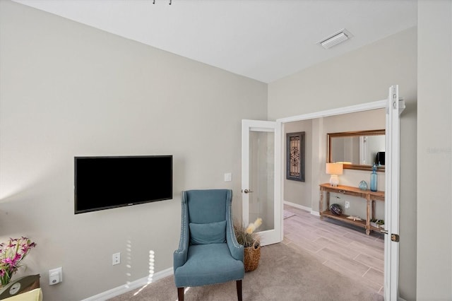 living area featuring french doors and light hardwood / wood-style floors