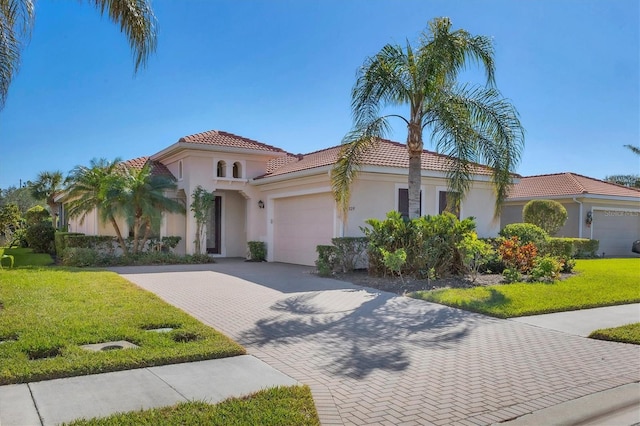 mediterranean / spanish home with a front yard and a garage