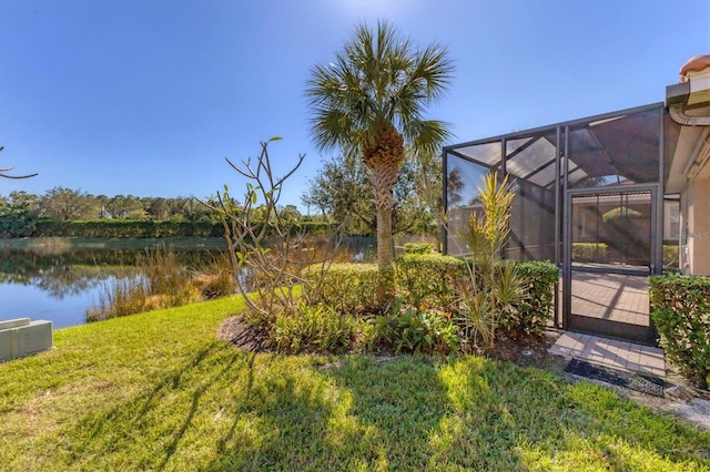 view of yard featuring glass enclosure and a water view