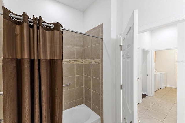 bathroom featuring washer and clothes dryer, shower / bath combo with shower curtain, and tile patterned floors