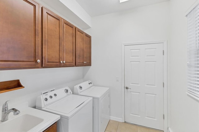 laundry area with washing machine and dryer, sink, light tile patterned flooring, and cabinets