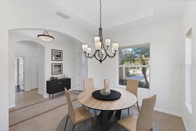 tiled dining space with a chandelier