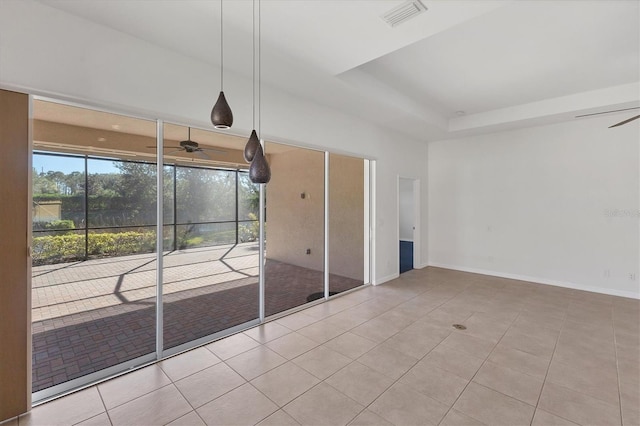 interior space with a tray ceiling and light tile patterned flooring