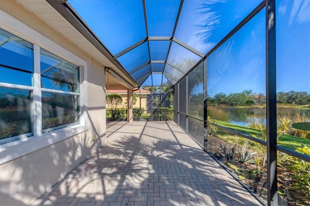 unfurnished sunroom featuring a water view and lofted ceiling