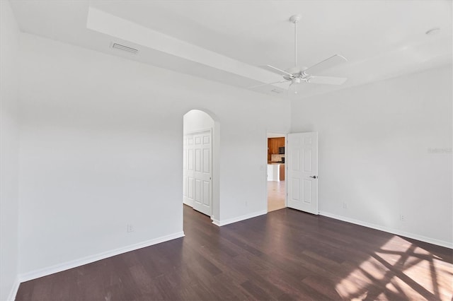 empty room with ceiling fan, dark hardwood / wood-style flooring, and a high ceiling