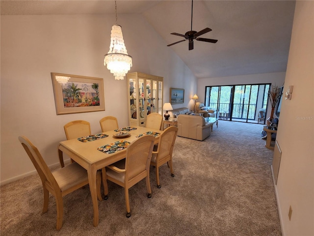 carpeted dining area with high vaulted ceiling and ceiling fan with notable chandelier