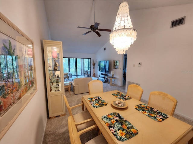 dining room featuring ceiling fan with notable chandelier, high vaulted ceiling, and light colored carpet