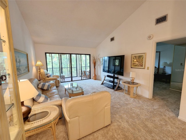 carpeted living room featuring high vaulted ceiling