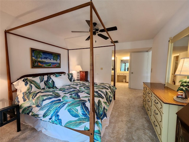 bedroom with ceiling fan, light carpet, and ensuite bathroom