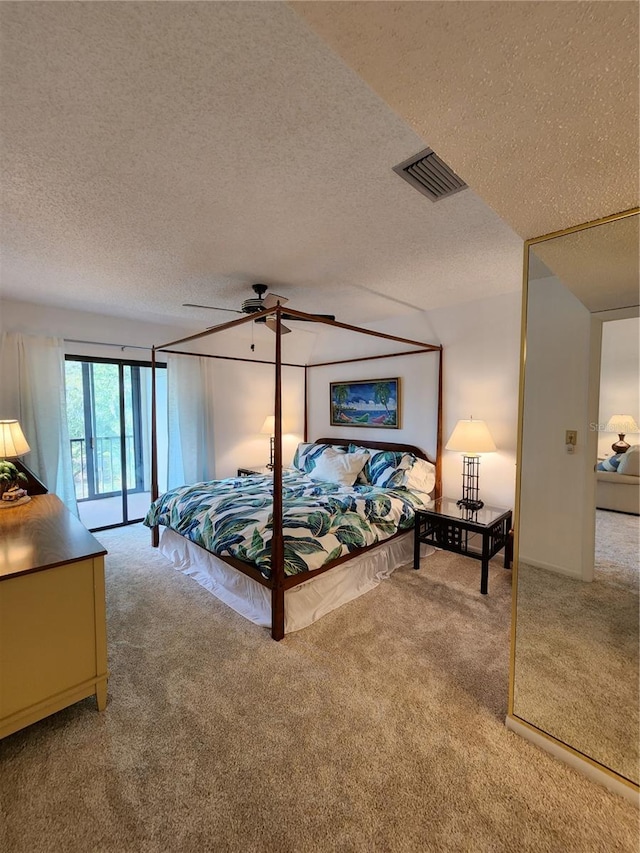 bedroom with a textured ceiling, carpet floors, and ceiling fan