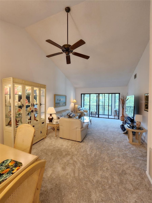 living room with ceiling fan, high vaulted ceiling, and light carpet