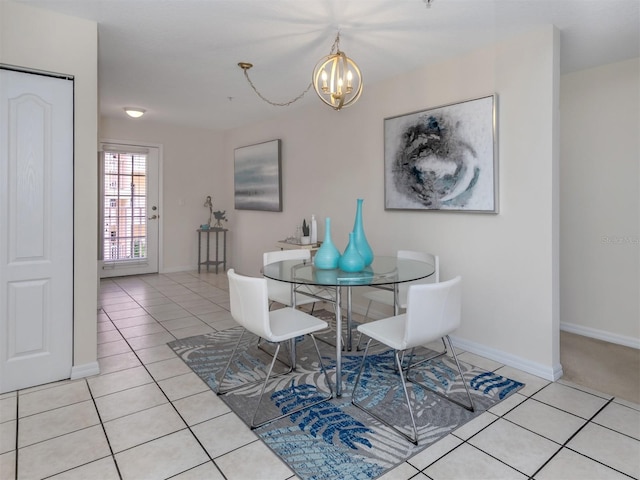 dining space with light tile patterned flooring, baseboards, and a notable chandelier