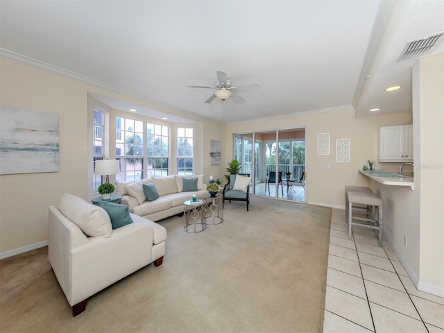 living room with visible vents, ornamental molding, light carpet, baseboards, and ceiling fan