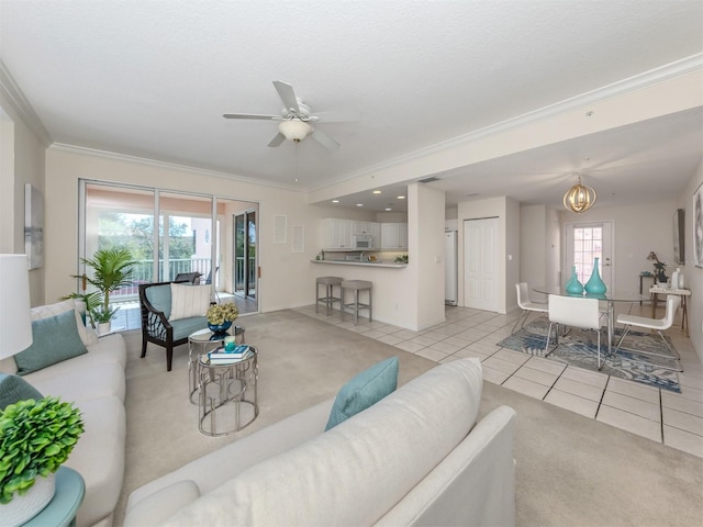 tiled living room featuring ornamental molding and ceiling fan with notable chandelier