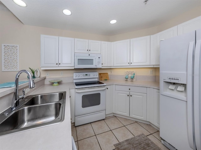 kitchen featuring white appliances, sink, a textured ceiling, white cabinets, and light tile patterned floors