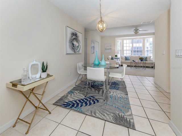 tiled dining room featuring ceiling fan with notable chandelier