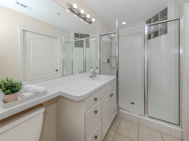 bathroom with vanity, toilet, a shower with shower door, and tile patterned flooring