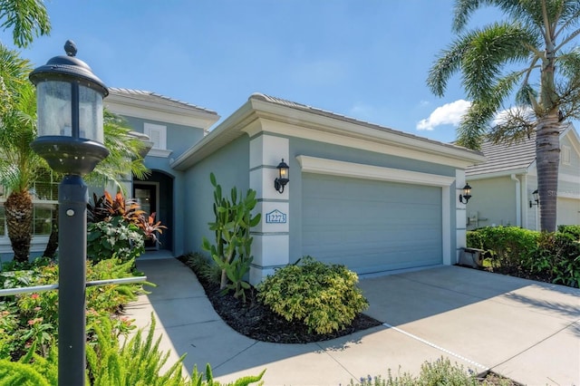 12273 Stuart Dr, Venice, FL 34293 - view of front of house with an attached garage, driveway, and stucco siding