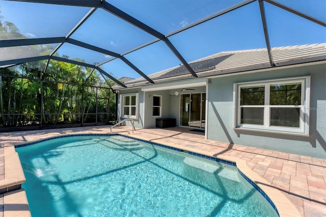 view of swimming pool with a lanai, ceiling fan, and a patio area