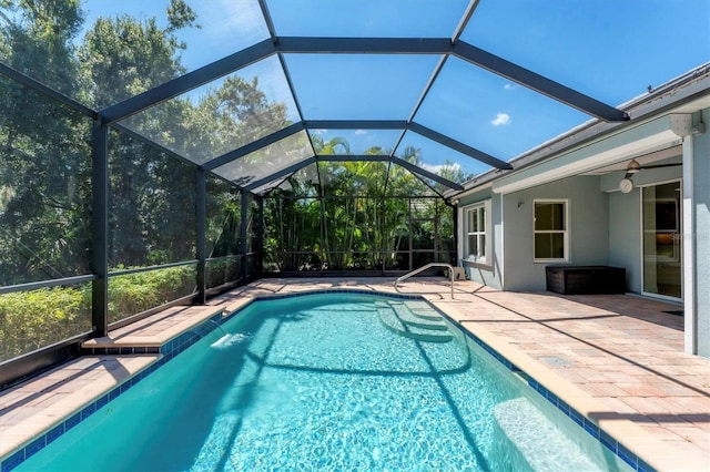 view of swimming pool featuring ceiling fan, a patio area, and a lanai