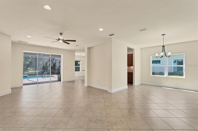 unfurnished room with ceiling fan with notable chandelier and light tile patterned floors