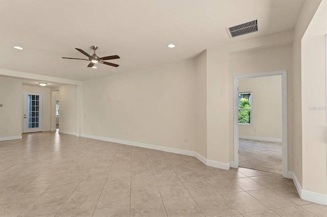 tiled spare room featuring ceiling fan