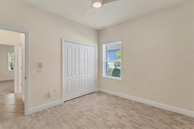 unfurnished bedroom with light carpet and a closet