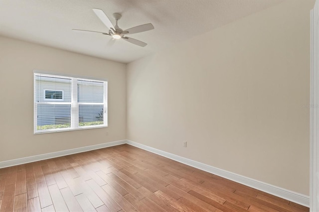 empty room with ceiling fan, a textured ceiling, and light wood-type flooring