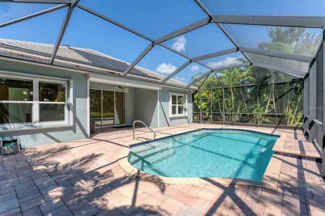 view of pool featuring glass enclosure, ceiling fan, and a patio area