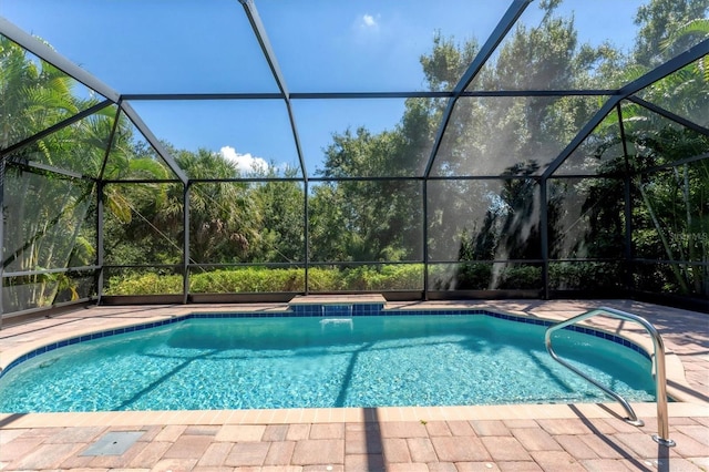 view of pool featuring glass enclosure and a patio