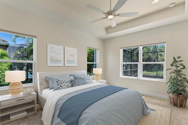 12273 Stuart Dr, Venice, FL 34293 - bedroom with baseboards, a ceiling fan, and a tray ceiling