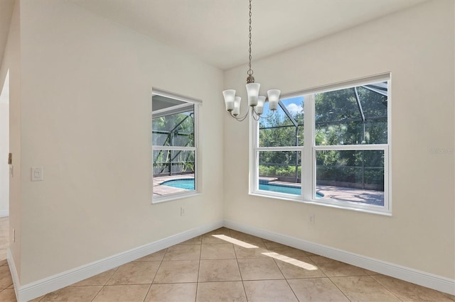 12273 Stuart Dr, Venice, FL 34293 - unfurnished dining area featuring light tile patterned floors, an inviting chandelier, a healthy amount of sunlight, and baseboards