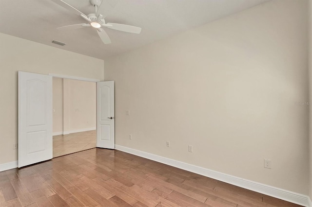 12273 Stuart Dr, Venice, FL 34293 - unfurnished bedroom with wood finished floors, visible vents, a ceiling fan, and baseboards