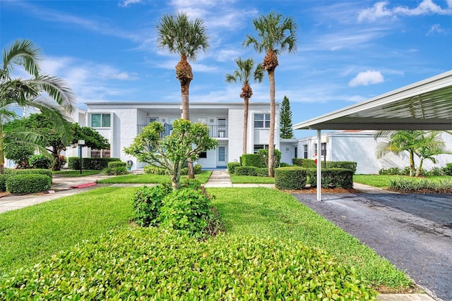 view of front of property featuring a carport and a front lawn