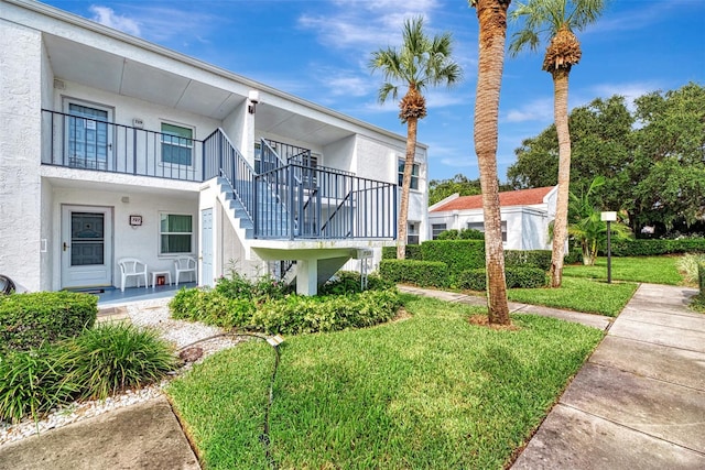 exterior space with a front yard and a balcony