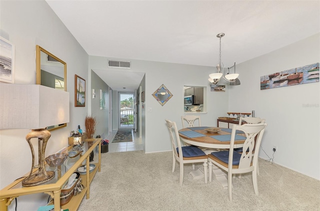 carpeted dining room featuring a chandelier